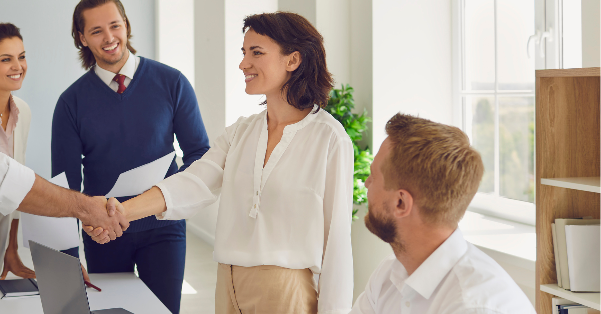 women shaking hands with colleagues
