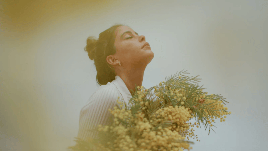 Positive Wellbeing Psychology Melbourne | How to Tame the Inner Critic and Cultivate Self-Compassion Woman holding flowers, representing self-compassion and nurturing mental wellbeing in a psychology clinic setting
