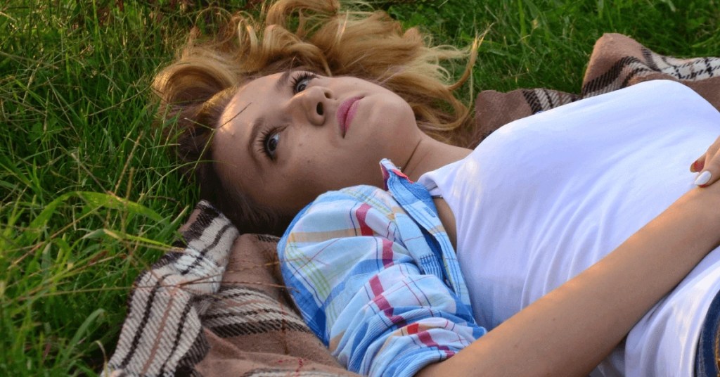 Young adult woman looking up at the sky, reflecting on her life and seeking guidance through ADHD therapy Melbourne with neurodiversity-affirming support