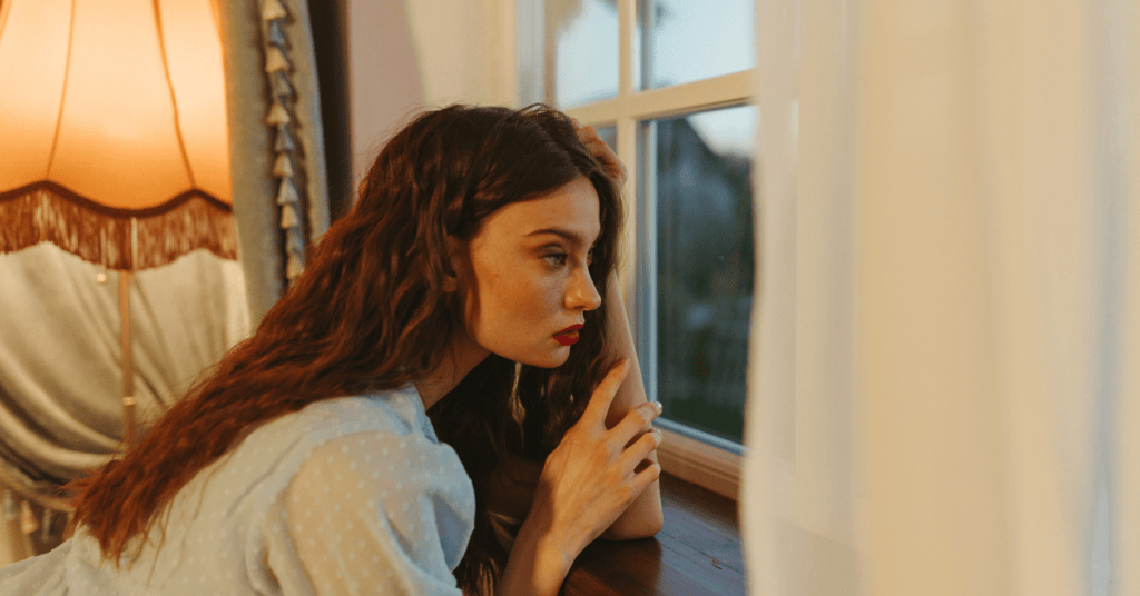 Positive Wellbeing Psychology Melbourne | Struggling to Adjust to a Big Life Change? Here's Why It's Harder Than You Think Woman looking out a window indoors