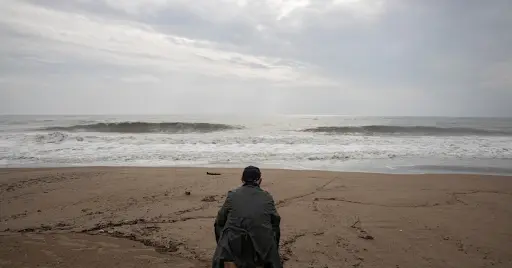 Positive Wellbeing Psychology Melbourne | Identity and Values: Feeling Stuck When You Don’t Know What You Want Person sitting alone on a beach overlooking the ocean