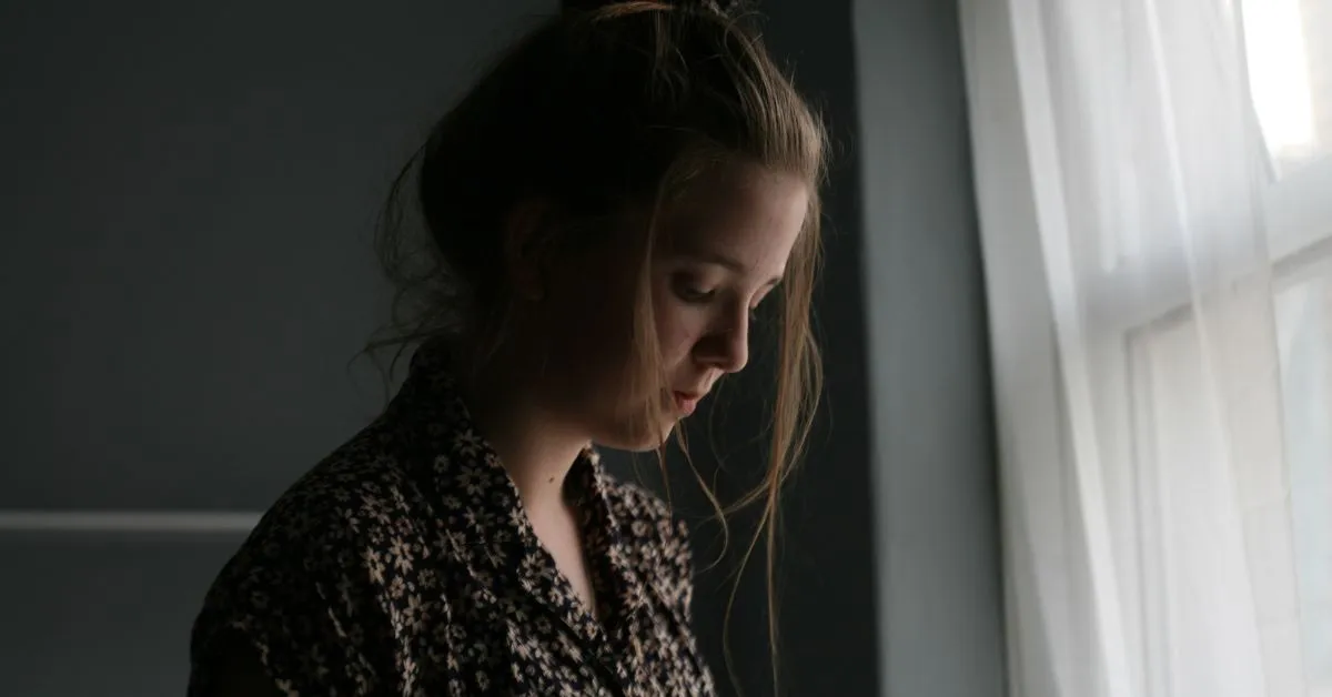 Young woman sitting by window