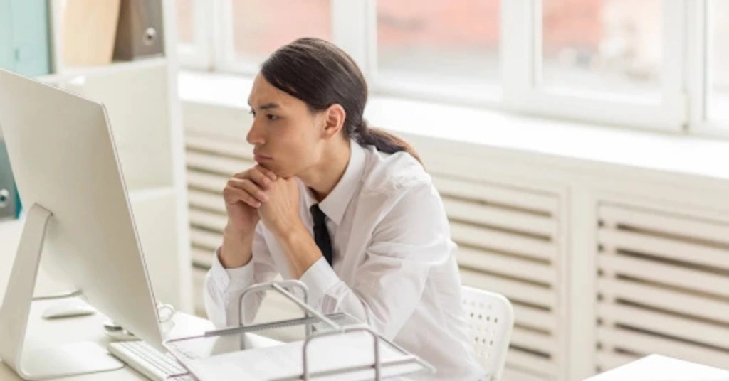 Positive Wellbeing Psychology Melbourne | Obsessive-Compulsive Disorder vs. Being Detail-Oriented: Where's the Line? Office worker leaning over a computer screen with a thoughtful and focused expression.