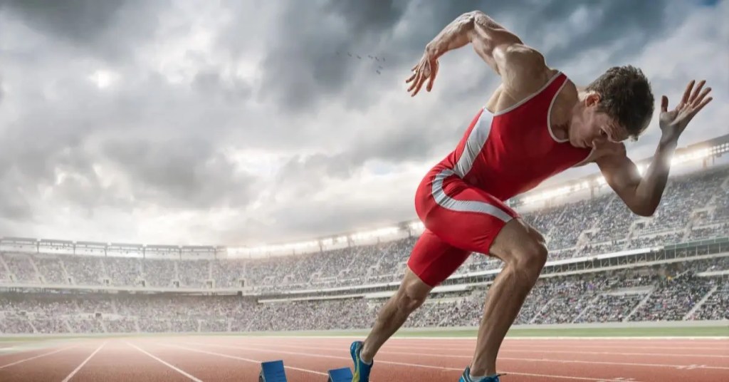 Positive Wellbeing Psychology Melbourne | Low Confidence in High Achievers: The Hidden Block Behind Success Male track sprinter exploding off starting blocks at a stadium running track